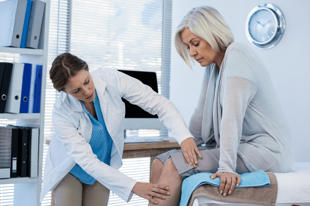 Un médico examina a un paciente con artrosis que necesita terapia.